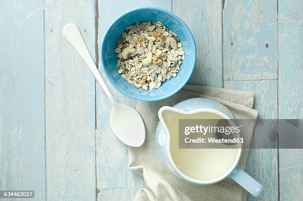 bowl of granola with walnuts, cashew nuts, sunflower seed and a milk jug - jug stock pictures, royalty-free photos & images