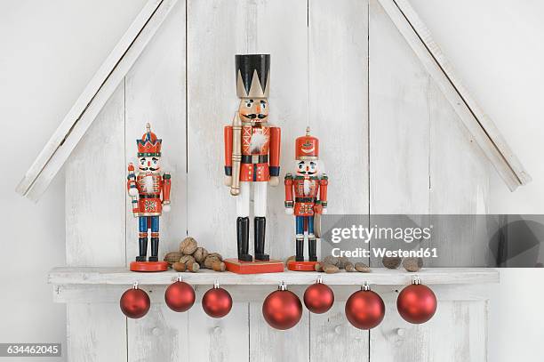 christmas decoration with three nutcrackers, christmas baubles and nuts - nutcracker stock pictures, royalty-free photos & images