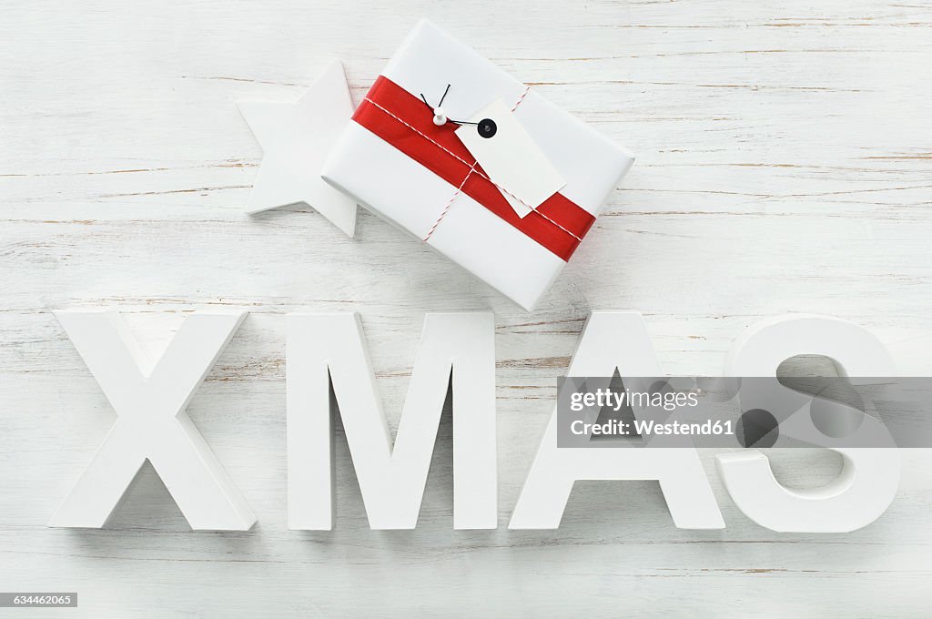 Christmas present and Christmas decoration with star and letters building the word 'Xmas'