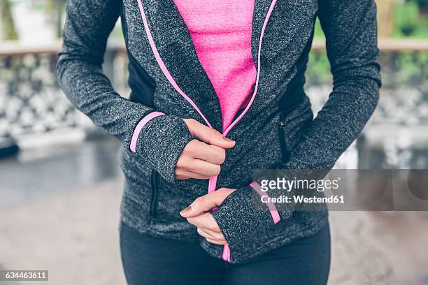 woman closing zipper of sportive jacket - sportswear stock pictures, royalty-free photos & images