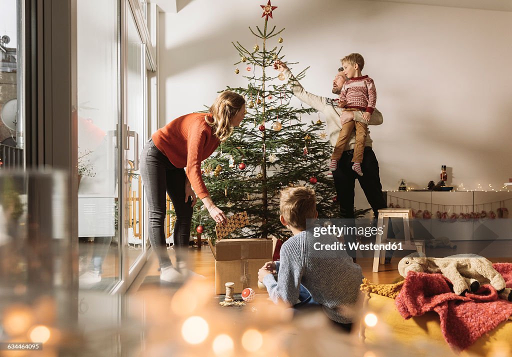 Family decorating Christmas tree