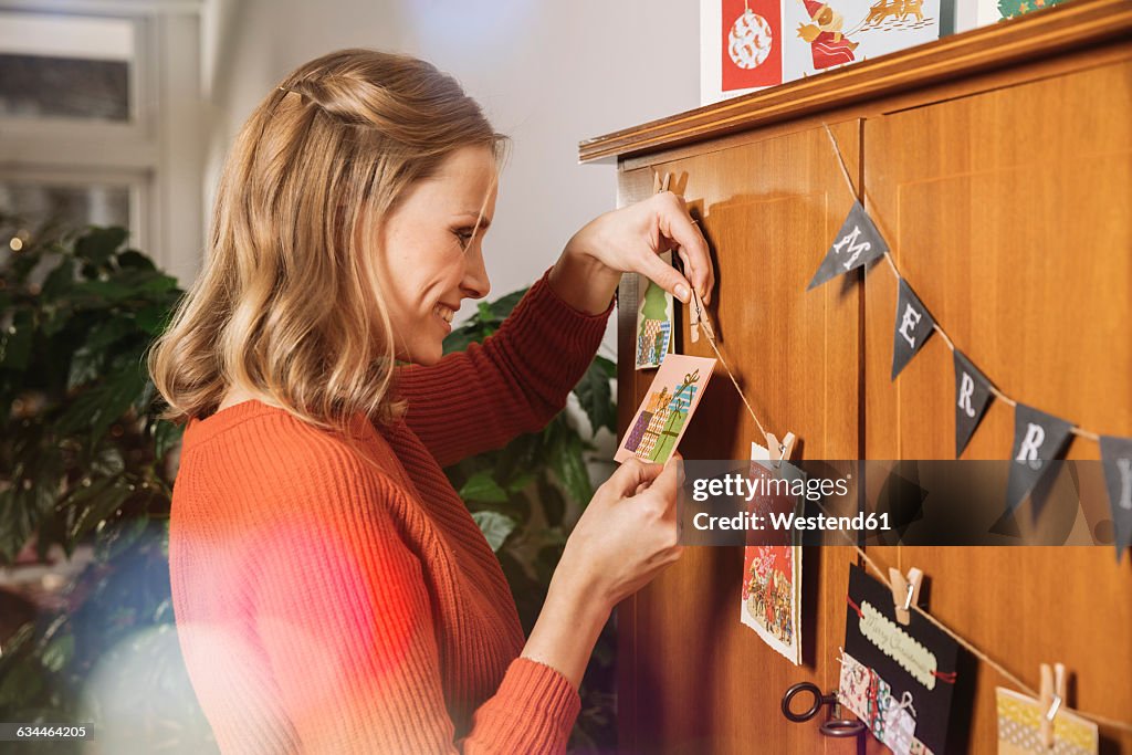 Woman hanging up Holiday cards for decoration