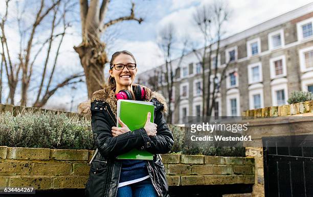 london, student girl with headphone and writing pad, language holiday - school holiday stock-fotos und bilder