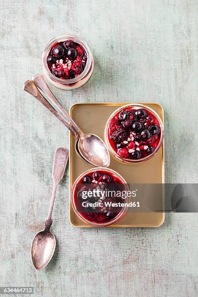 glasses of vanilla cream with berry sauce and chopped almonds - griesmeelpap stockfoto's en -beelden