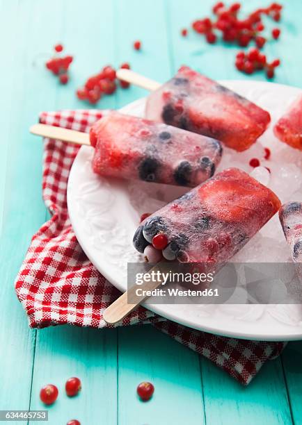 fruits ice lolly with fresh berries - strawberry ice cube studio stock-fotos und bilder