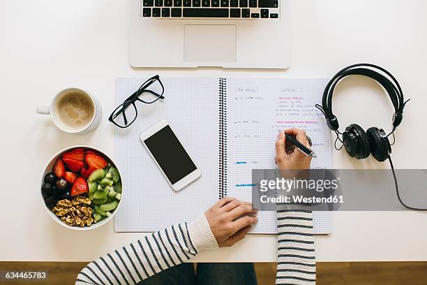 woman at desk writing on notepad - notepad table stockfoto's en -beelden
