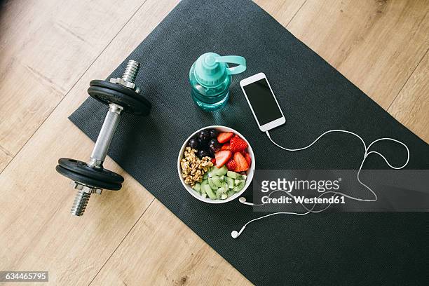 dumbbell, drinking bottle, fruit bowl and smartphone with earphones - tatame equipamento para exercícios - fotografias e filmes do acervo