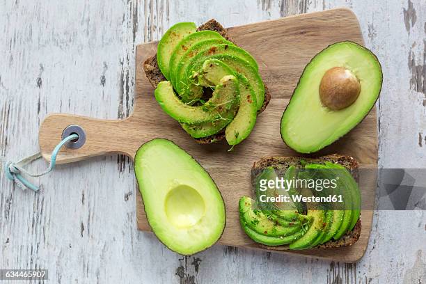 protein bread garnished with sliced avocado, cress and chili powder - avocado stock pictures, royalty-free photos & images