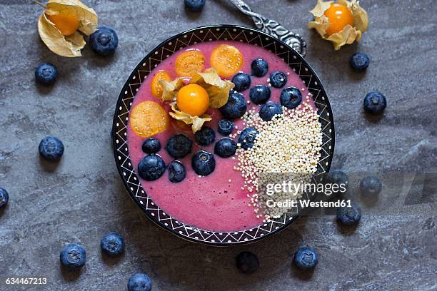 bowl of blueberry smoothie with popped amarant, blueberries and physalis - amarant stock pictures, royalty-free photos & images