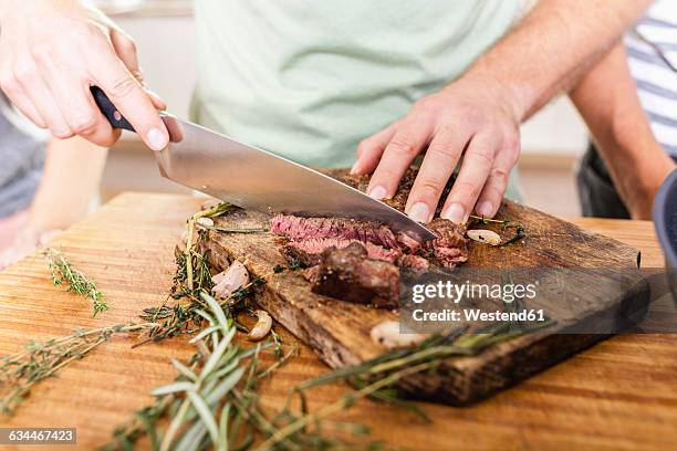 cutting steak on chopping board - hacken essenszubereitung stock-fotos und bilder