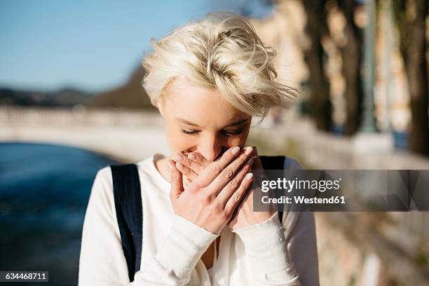 italy, verona, blond woman covering mouth with her hands - hands covering mouth stock pictures, royalty-free photos & images