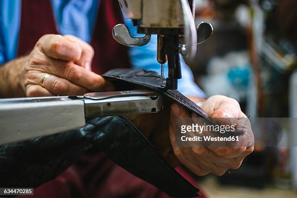 shoemaker sewing a shoe with machine in his workshop, close-up - shoe factory stock pictures, royalty-free photos & images