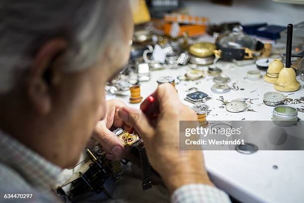 watchmaker in foreground while working with a wristwatch - 時計職人 ストックフォトと画像