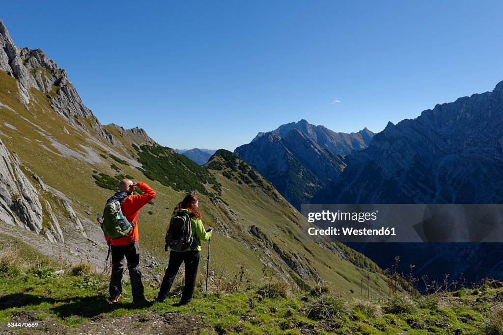 Austria, Tyrol, Karwendel, hikers looking at view at the Torscharte
