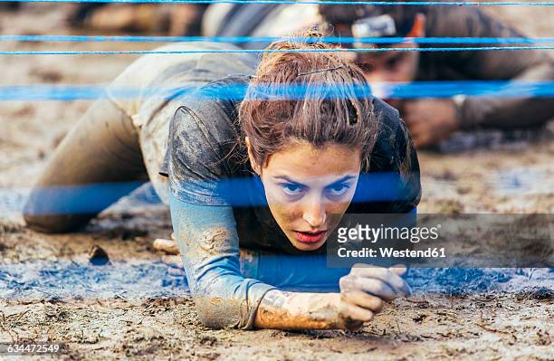 participants in extreme obstacle race crawling under electric wire - gijon ストックフォトと画像
