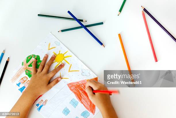 hands of little girl painting with coloured pencils - kids drawing stock-fotos und bilder