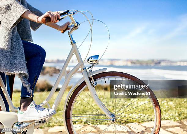 woman riding bicycle at the coast - female driving stock-fotos und bilder