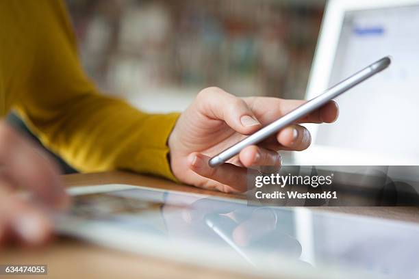 woman at table using smartphone - ipad close up stock pictures, royalty-free photos & images