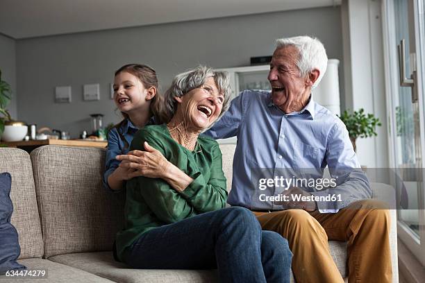 little girl and her grandparents having fun at home - senior men laughing stock pictures, royalty-free photos & images