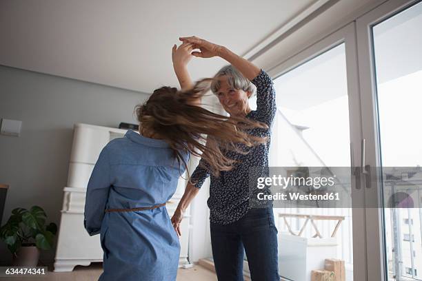 little girl dancing with her grandmother at home - grandmas living room stock pictures, royalty-free photos & images