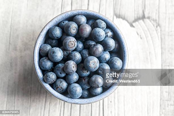 bowl of blueberries on wood - ブルーベリー ストックフォトと画像
