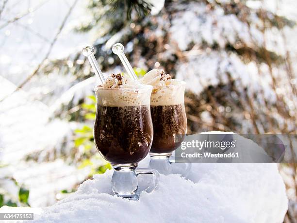 two glasses pharisee with coffee, rum and cream, in snow - irish coffee stock-fotos und bilder