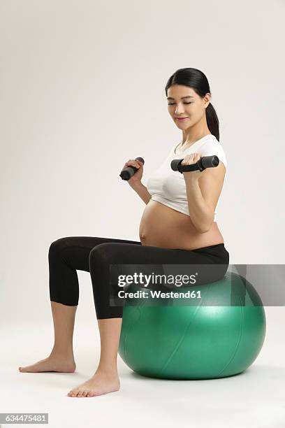 pregnant woman exercising on fitness ball - pregnancy yoga ball stock pictures, royalty-free photos & images