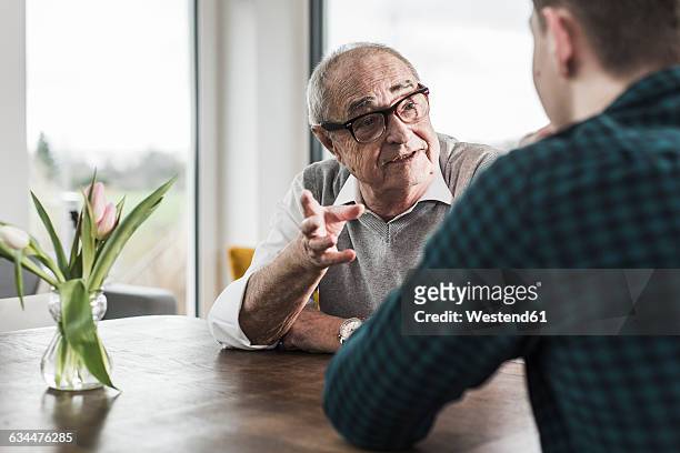 portrait of senior man communicating with his grandson - narrar fotografías e imágenes de stock