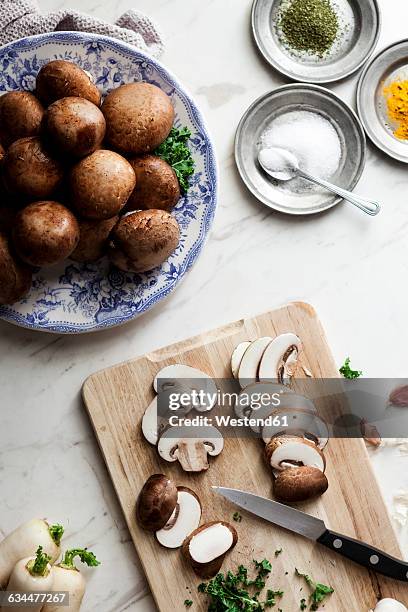 sliced portobello mushrooms, parsley and kitchen knife on wooden board - portobello mushroom stock pictures, royalty-free photos & images