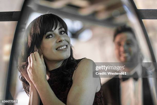 elegant woman putting on earrings - traje a rigor imagens e fotografias de stock