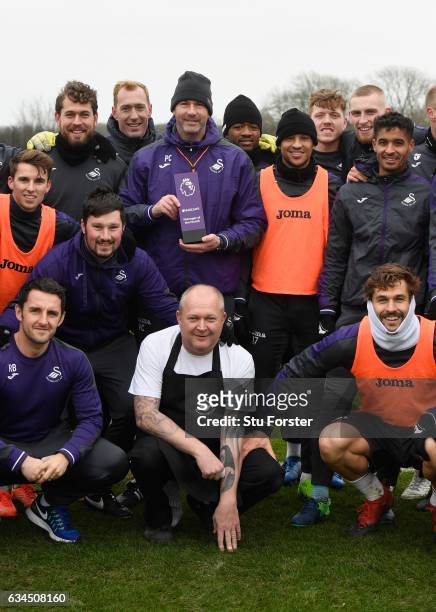 Swansea City manager Paul Clement with his Barclays Manager of the Month award and players and staff at Swansea City's training ground at Fairwood on...