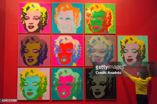 Museum staff makes final adjustments to a selection of ten colour Andy Warhol screen prints featuring Marilyn Monroe installed in the British Museums...