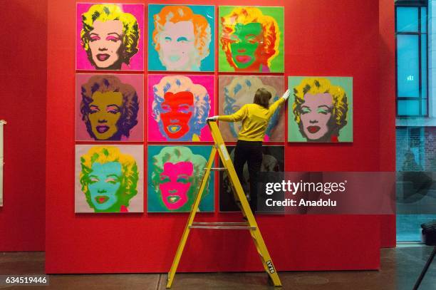 Museum staff makes final adjustments to a selection of ten colour Andy Warhol screen prints featuring Marilyn Monroe installed in the British Museums...