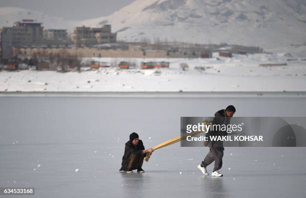 Afghan youths play on the frozen Qargha Lake on the outskirts of Kabul on February 10, 2017.
