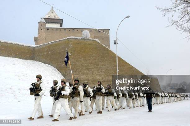 Army soldiers and Estonian Army scouts marching on the river promenade next Narva Medieval Castle at Estonian - Russia border in Narva during their 3...