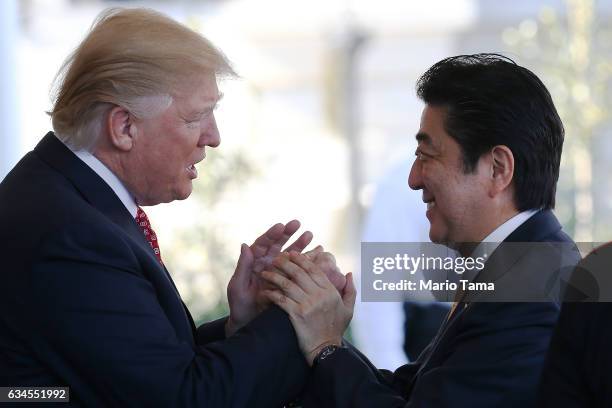 President Donald Trump greets Japan's Prime Minister Shinzo Abe as he arrives at the White House on February 10, 2017 in Washington, DC. The two will...