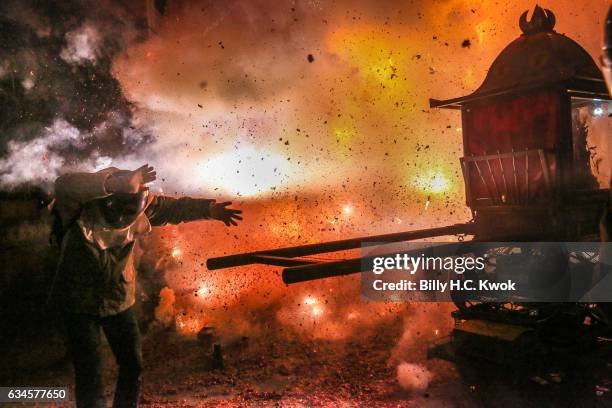 People wearing helmets get sprayed by fire sparks during the Yanshui Beehive Rockets Festival on February 10, 2017 in Yanshui District, Tainan City,...