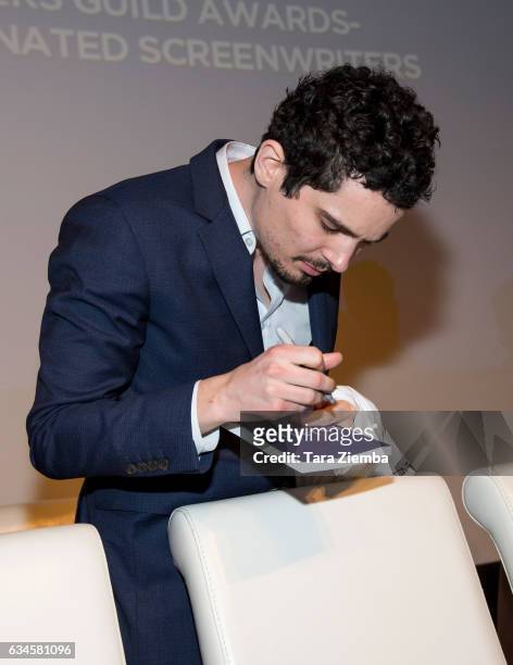 Writer Damien Chazelle autograpahs memorbilia for guests during the 2017 Writers Guild's annual Beyond Words panel event at Writers Guild Theater on...