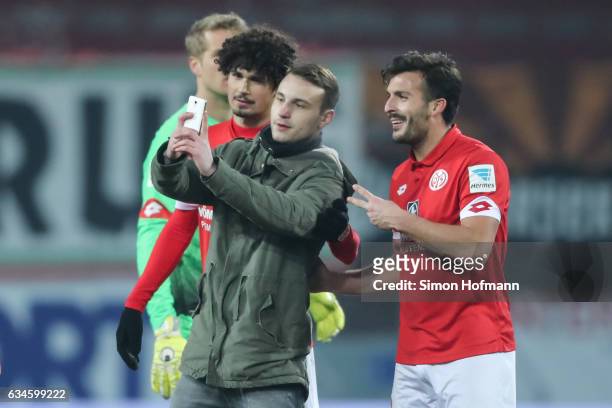 Pitch invader takes a selfie with Giulio Donati of Mainz during the Bundesliga match between 1. FSV Mainz 05 and FC Augsburg at Opel Arena on...