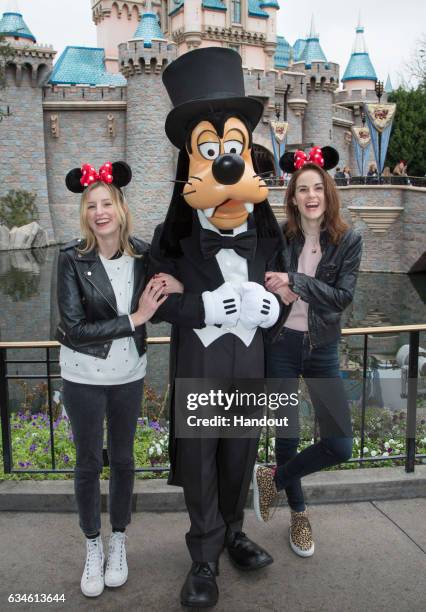 In this handout photo provided by Disney Parks, "Downton Abbey" stars Laura Carmichael and Michelle Dockery meet Goofy at Sleeping Beauty Castle at...