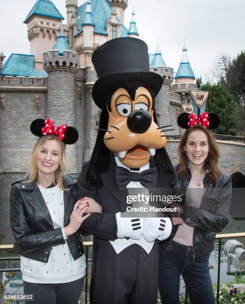 In this handout photo provided by Disney Parks, "Downton Abbey" stars Laura Carmichael and Michelle Dockery meet Goofy at Sleeping Beauty Castle at...