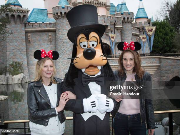 In this handout photo provided by Disney Parks, "Downton Abbey" stars Laura Carmichael and Michelle Dockery meet Goofy at Sleeping Beauty Castle at...