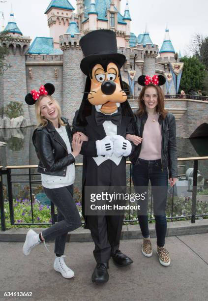 In this handout photo provided by Disney Parks, "Downton Abbey" stars Laura Carmichael and Michelle Dockery meet Goofy at Sleeping Beauty Castle at...