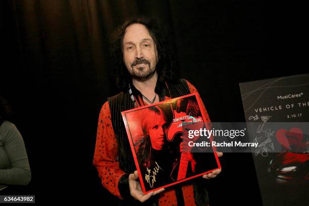 Musician Mike Campbell poses with the charity signings at MusiCares Person of the Year honoring Tom Petty during the 59th GRAMMY Awards at Los...