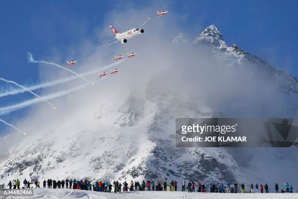 An Airbus commercial plane of Swiss International Air Lines flies with fighter jets of the "Patrouille Suisse" perform before the downhill race of...
