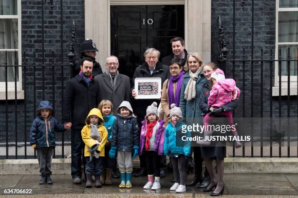 Lord Alf Dubs poses for journalists with supporters outside 10 Downing Street in London on February 11 before handing in a petition calling on the...
