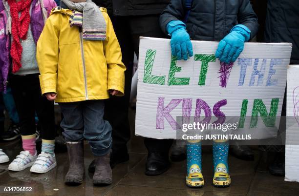 Child holds a placard that reads "Let the kids in" as people gather to hear speeches on Whitehall before Lord Alf Dubs handed in a petition to 10...