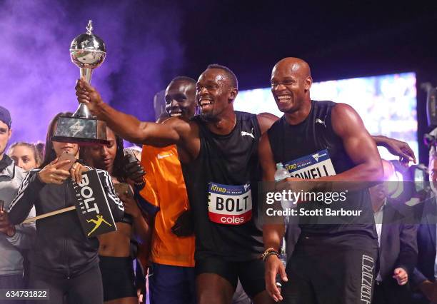 Usain Bolt and Asafa Powell of Usain Bolt's All-Star team celebrate with the trophy after winning the event during the Melbourne Nitro Athletics...