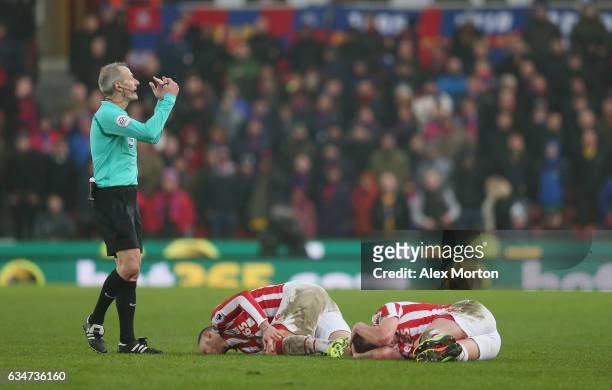 Marko Arnautovic and Charlie Adam lie injured during the Premier League match between Stoke City and Crystal Palace at Bet365 Stadium on February 11,...
