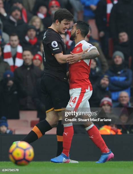 Arsenal's Theo Walcott clashes with Harry Maguire of Hull during the Premier League match between Arsenal and Hull City at Emirates Stadium on...